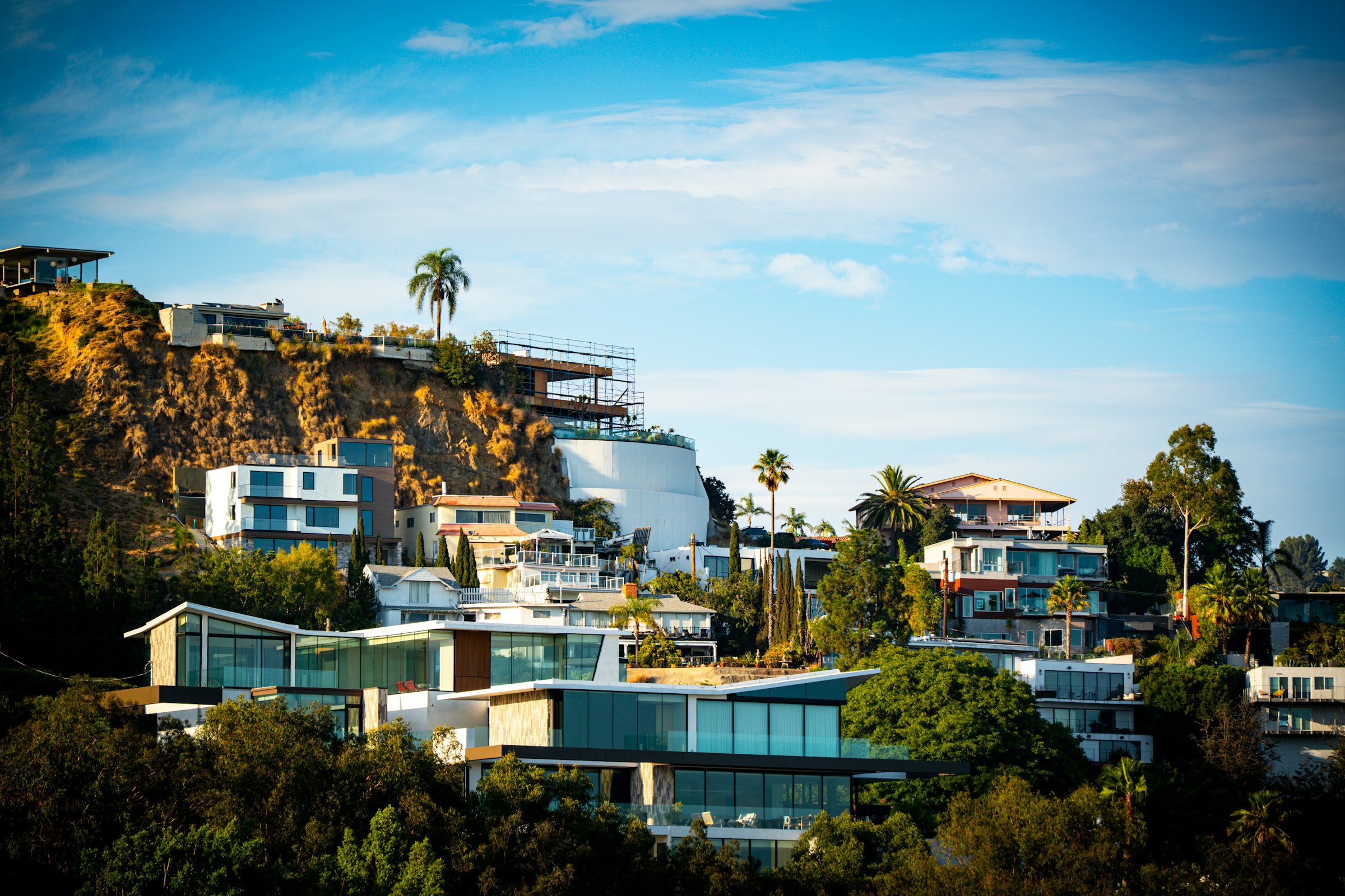 Casas modernas integradas en una ladera arbolada de West Hollywood, California, a la luz del atardecer
