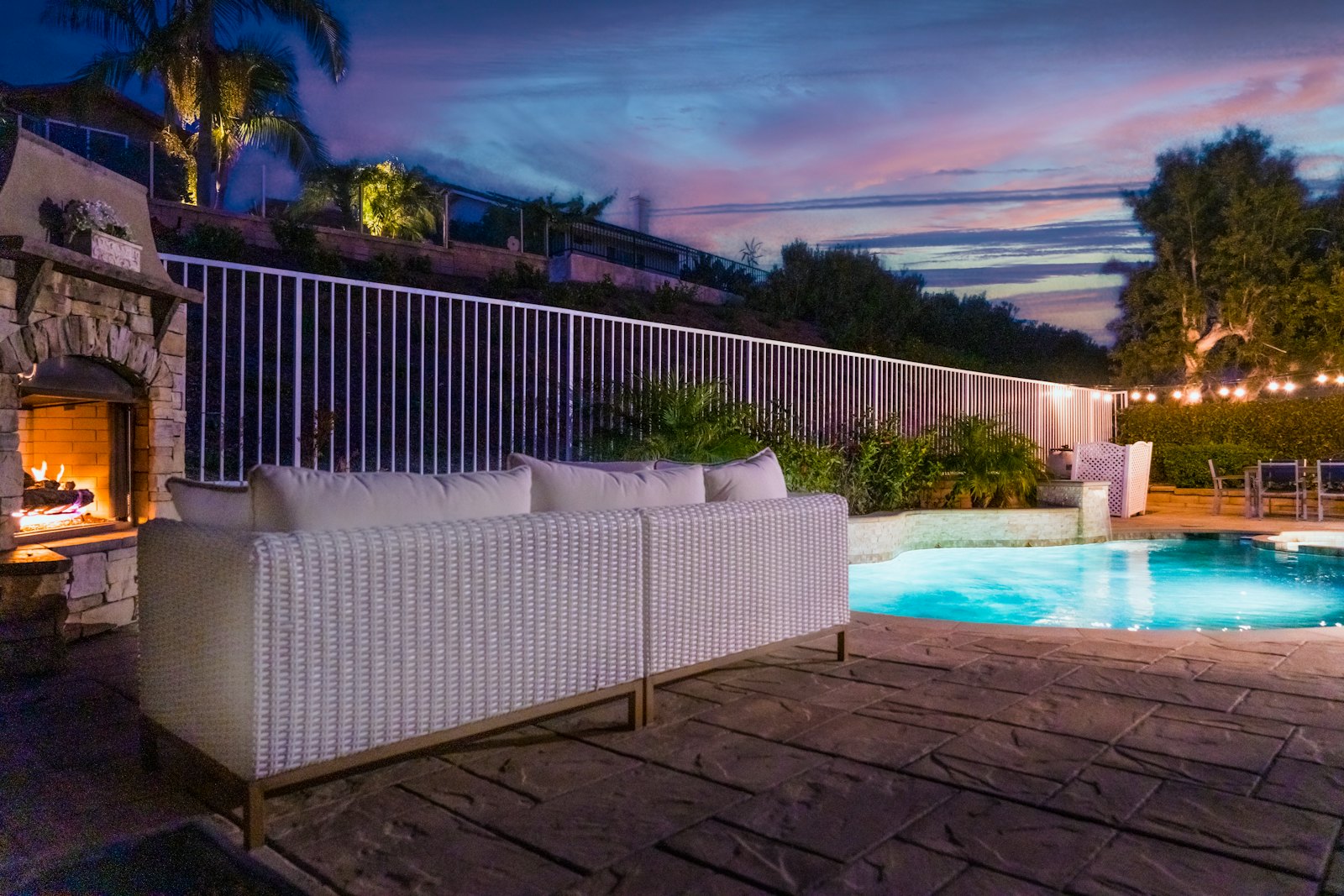 Terraza con chimenea y alberca al atardecer en San Clemente, California